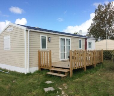 Mobil-home avec terrasse en bois et pelouse au Camping de la Plage
