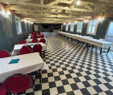 Salle intérieure avec carrelage damier et tables au Camping de la Plage