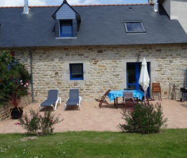 Terrasse avec chaises longues et table dans le jardin du Camping de la Plage de Cleut-Rouz