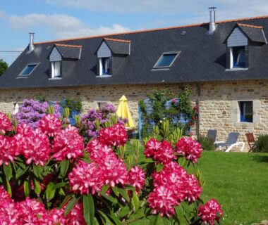 Jardin fleuri devant bâtiment en pierre au Camping de la Plage de Cleut-Rouz