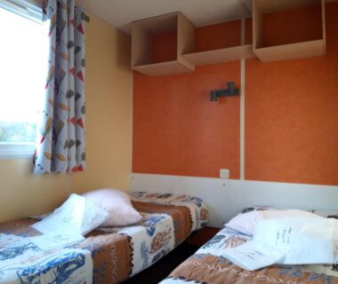 Chambre avec deux lits simples et fenêtre dans le Camping de la Rive