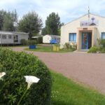 Allée et bâtiment d'accueil avec mobil-homes au Camping de la Rive