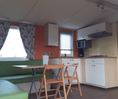 Intérieur kitchenette avec banquette et table dans le mobil-home du Camping de la Rive
