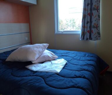 Chambre avec lit et fenêtre au Camping de la Rive