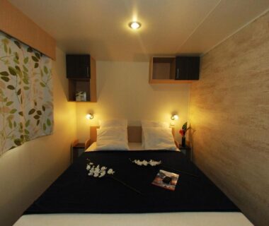 Chambre avec lit double et lampes dans le Camping de la Treille