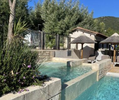 Piscine extérieure avec bassins et parasols au Camping de la Treille
