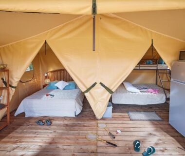 Intérieur de tente lodge avec lits et kitchenette au Camping des Papillons