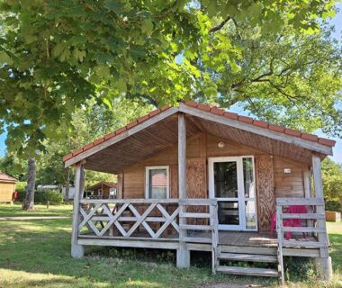 Bungalow en bois avec terrasse sous arbre au Camping des Papillons