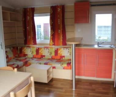 Intérieur avec kitchenette et banquette colorée dans le Camping des Roses