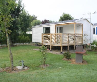 Emplacement gazonné avec mobil-home et terrasse au Camping des Roses