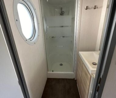 Salle de bain avec cabine de douche et hublot dans le Camping domaine Saint Martin 4 étoiles