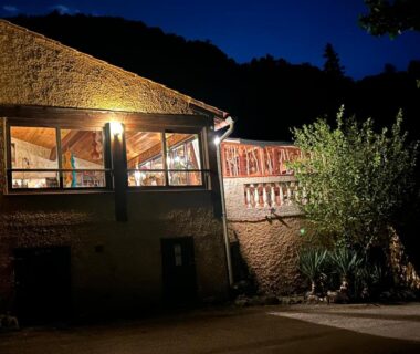 Façade éclairée et terrasse de nuit au Camping domaine Saint Martin 4 étoiles
