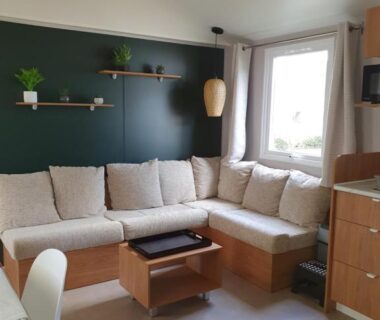 Intérieur mobil-home coin salon avec canapé et table basse au Camping du Bois Dormant