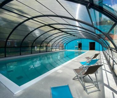 Piscine couverte avec chaises longues au Camping du Chêne