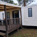 Terrasse couverte avec table et chaises devant mobil-home du Camping du Domaine de la Forge