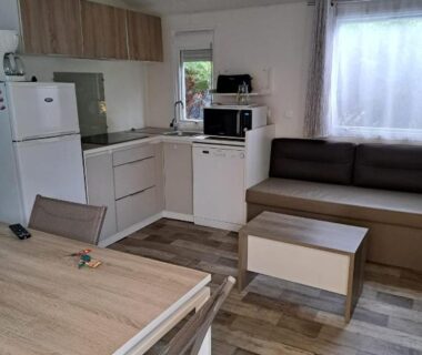 Intérieur du logement avec kitchenette et coin salon au Camping du Domaine de la Forge