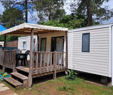 Terrasse en bois et mobil-home dans les pins au Camping du Domaine de la Forge