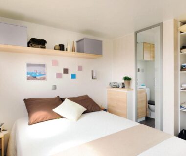 Chambre avec lit double et rangements au Camping du Lac