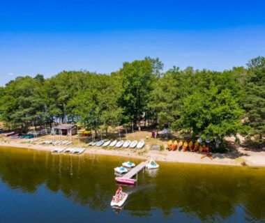 Plage du lac avec ponton et bateaux au Camping du Lac