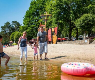 Plage du lac avec famille et aire de jeux au Camping du Lac