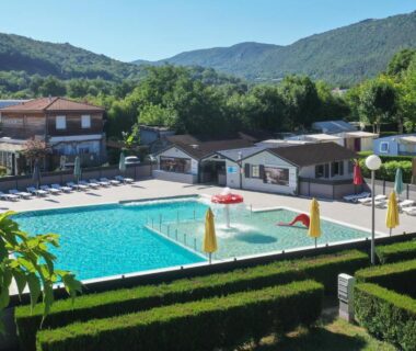 Piscine extérieure avec pataugeoire et transats au Camping du Lac