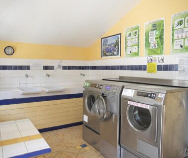 Buanderie avec lave-linge et lavabos au Camping du Lac