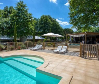 Piscine extérieure avec transats et parasol au Camping du Lac de Grolejac