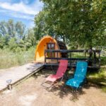 Terrasse avec deux chaises longues devant un pod au Camping du Moulin de Thoard