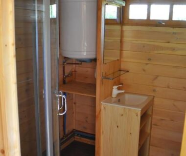 Salle d'eau en bois avec douche et chauffe-eau au Camping du Moulin de Thoard