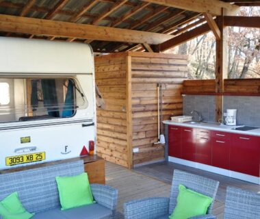 Abri couvert avec caravane coin cuisine et salon au Camping du Moulin de Thoard