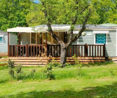 Terrasse en bois et arbre devant mobil home au Camping du Moulin de Thoard