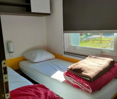 Chambre avec deux lits simples et store au Camping du Moulin de Thoard