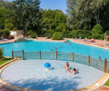 Piscine extérieure avec petit bassin et transats au Camping du Pont d’Avignon