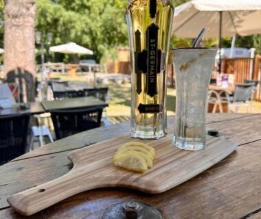 Terrasse avec bouteille et verre sur planche en bois au Camping du Pont d'Avignon