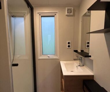Salle de bain avec douche vitrée et vasque au Camping du Valentin