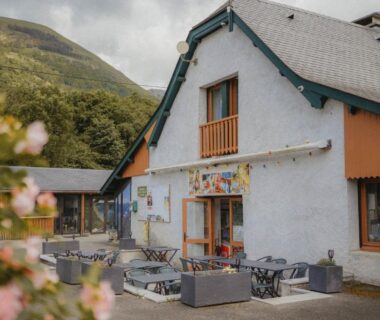 Façade et terrasse avec salons extérieurs au pied des montagnes au Camping du Valentin