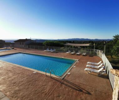 Piscine extérieure avec transats au Camping du Vignal