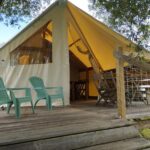 Terrasse en bois avec chaises et tente aménagée au Camping du pont d'Oust