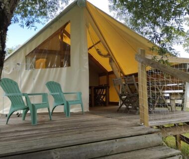 Terrasse en bois avec chaises et tente aménagée au Camping du pont d'Oust