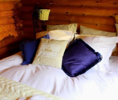 Chambre intérieure avec lit et coussins dans le chalet du Camping écovillage Soleil du Pibeste