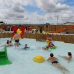 Bassin pour enfants avec toboggan et jeux aquatiques au Camping et Gîte La Garenne de Moncourt Baie Somme