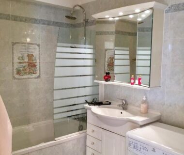 Salle de bains avec baignoire douche miroir et lave-linge au Camping et Gîte La Garenne de moncourt baie somme