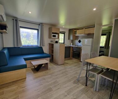 Intérieur mobil-home avec coin salon et kitchenette au Camping et Gîte La Garenne de Moncourt Baie Somme
