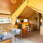 Intérieur de lodge avec coin salon et kitchenette dans le Camping et Lodges de Coucouzac