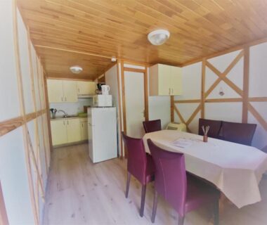 Intérieur avec coin repas et kitchenette dans les chalets d'Uza