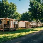 Allée de mobil-homes et pelouse ombragée au Camping intercommunal de Beaurepaire