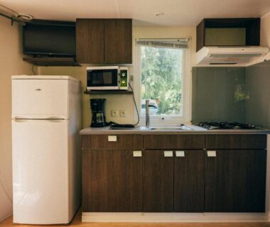 Coin cuisine équipé avec réfrigérateur et plaque de cuisson dans le mobil-home du Camping intercommunal de Beaurepaire