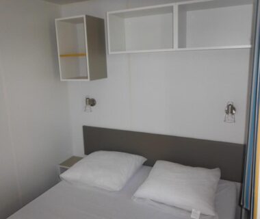 Chambre avec lit double rangements et liseuses au Camping l'Eléphant