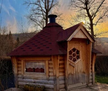 Sur la terrasse petite cabane en bois au toit rouge du Camping l'Estela sur le GR70