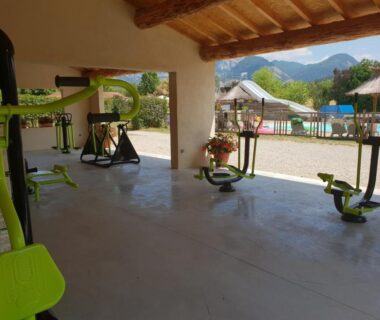 Espace fitness couvert avec vue sur la piscine au Camping l'Hirondelle Drôme
